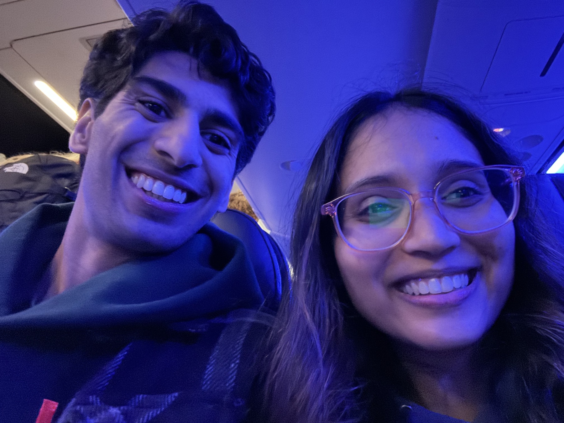 Keerthana and Yagnya smiling on a plane