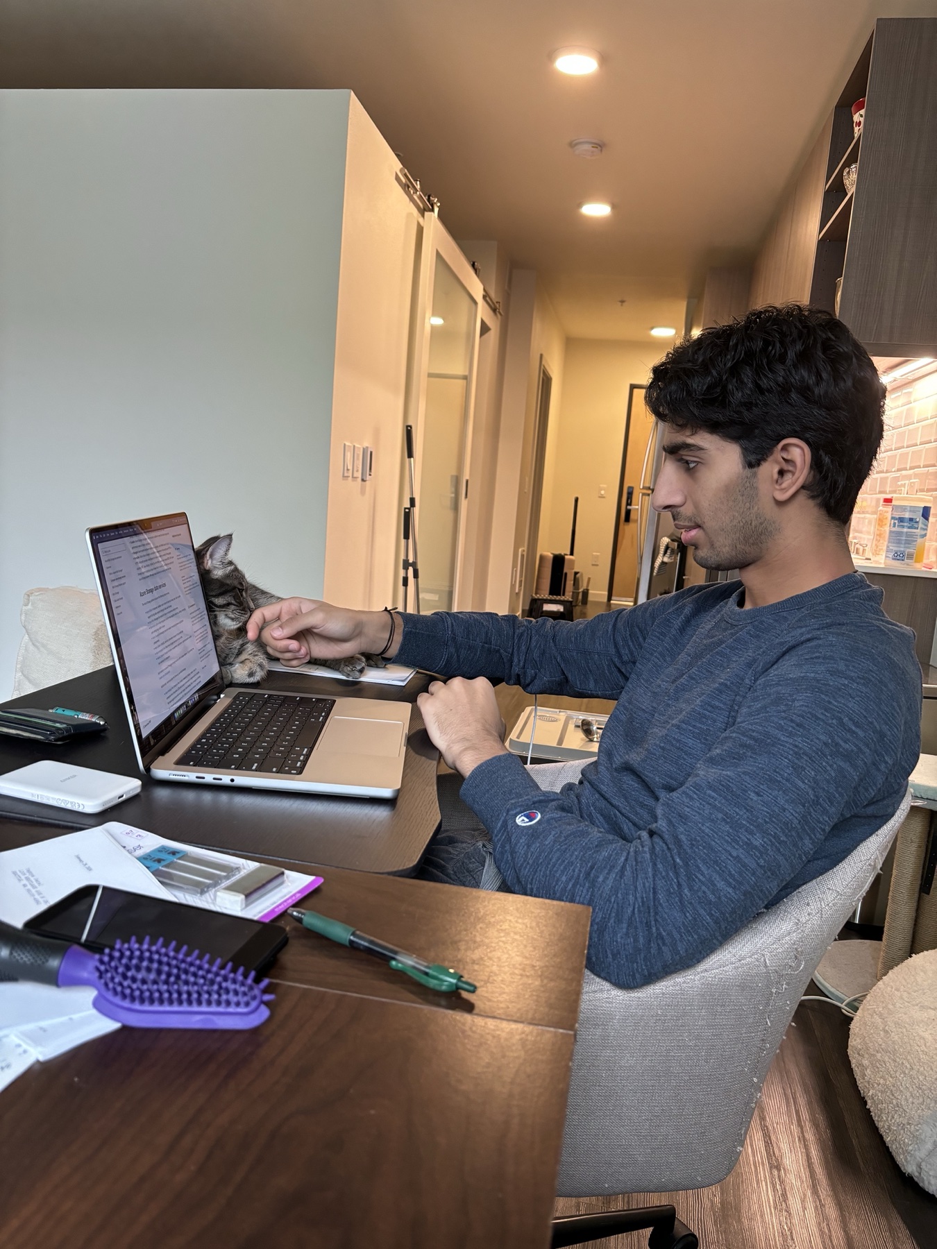 Yagnya working with a cat by his laptop